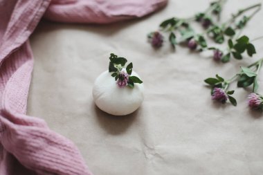 Çiçekli doğal organik sabun ve el işi kağıdının üzerinde pembe havlu.