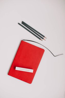 Okul konseptine, okul ve ofis malzemelerine, beyaz arkaplandaki defter ve kalemlere geri dönelim.