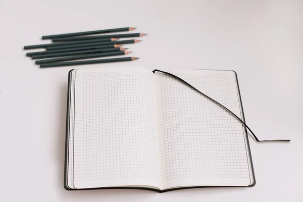 Concept de retour à l'école, fournitures scolaires et de bureau, vue du dessus du carnet et crayons sur fond blanc — Photo