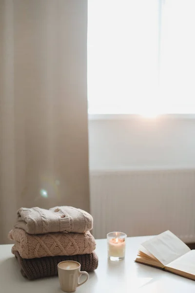 Hangulatos kényelmes hygge otthoni hangulat és csendes élet egy csésze, gyertya és pulóverek — Stock Fotó