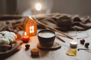 Sonbahar, bir fincan, mumlar ve ekoseyle sakin bir hayat. Hygge, Cadılar Bayramı ve Şükran Günü konsepti 