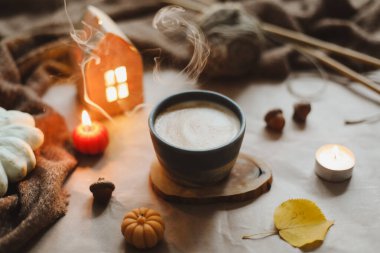 Sonbahar, bir fincan, mumlar ve ekoseyle sakin bir hayat. Hygge, Cadılar Bayramı ve Şükran Günü konsepti 