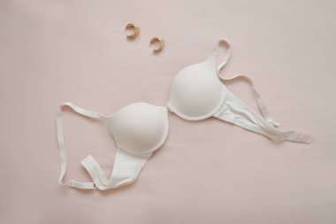 Bej arkaplan takılı beyaz dantel sutyen.