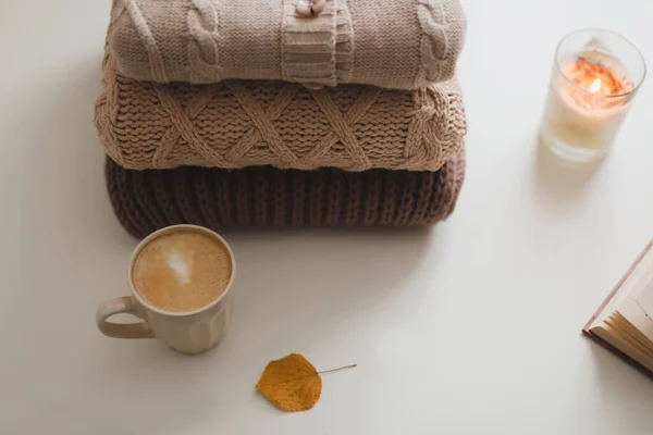Ambiente acolhedor e confortável casa hygge e ainda a vida com uma xícara, vela e suéteres — Fotografia de Stock