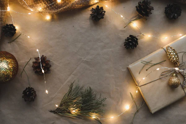 Karácsonyi kompozíció. Fenyő és fenyő ágakból és tobozokból készült keret, kézműves papír háttérrel. Lapos fekvés, felülnézet, másolás — Stock Fotó