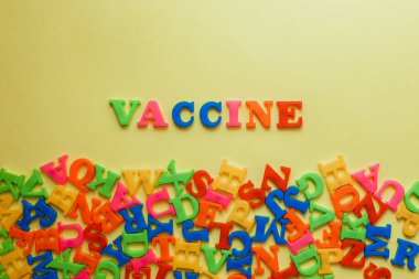 the word vaccine on a yellow background. Vaccination concept