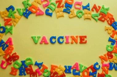the word vaccine on a yellow background. Vaccination concept