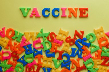 the word vaccine on a yellow background. Vaccination concept