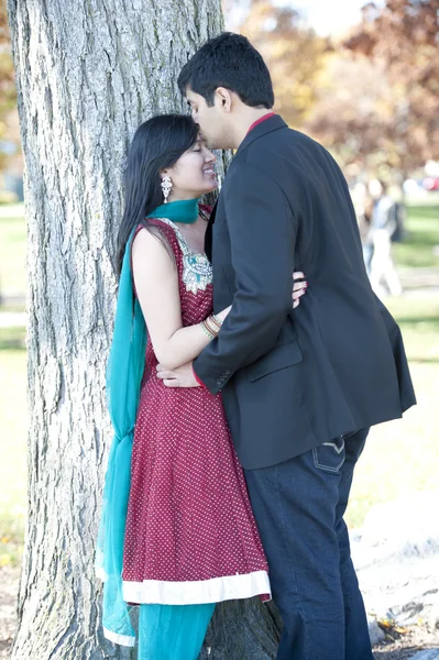 Joven hombre indio feliz besando a su novia en la frente — Foto de Stock
