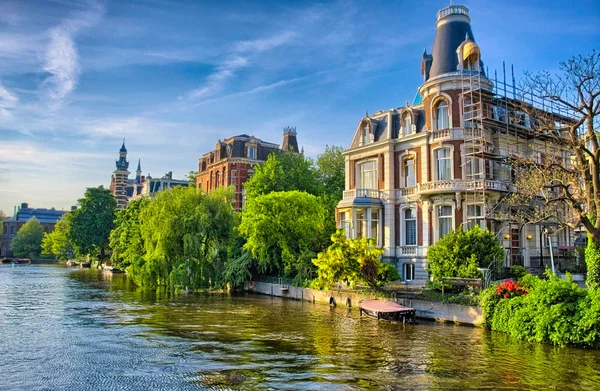 Rzeki Amstel z pięknych domów w Amsterdam, Holandia, Nether — Zdjęcie stockowe