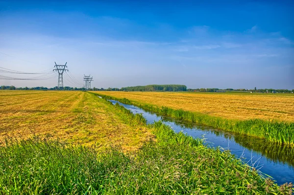 Nederlandse landschap met een kanaal en gras velden met spiegel reflectie — Stockfoto