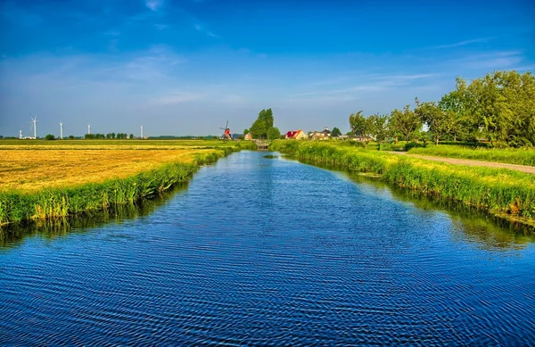 Paisaje holandés con un canal y campos de hierba con reflejo de espejo — Foto de Stock