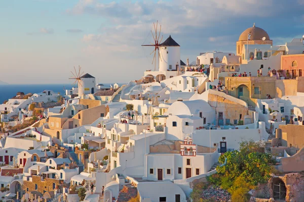 SANTORINI, GRECIA - 4 DE OCTUBRE DE 2015: La mirada a parte de Oia con los molinos de viento a la luz de la tarde. —  Fotos de Stock