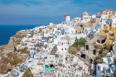 Santorini, Yunanistan - 5 Ekim 2015: Yel değirmenleri ve lüks tatil köyleri ile Oia'nın bir kısmına bakış.