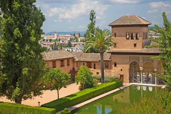 Granada, Spanje - 30 mei 2015: De tuinen van het Alhambra Paleis en Sint Nicolaas kerk in de achtergrond. — Stockfoto