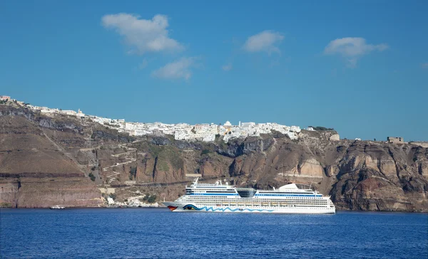 SANTORINI, GRECIA - 7 DE OCTUBRE DE 2015: Los acantilados de calera con el crucero y la ciudad de Fira en el fondo . —  Fotos de Stock