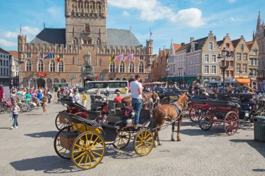 BRUGES, BELGIUM - 13 Haziran 2014: The Carriage on the Grote Markt and Belfort van Brugge.