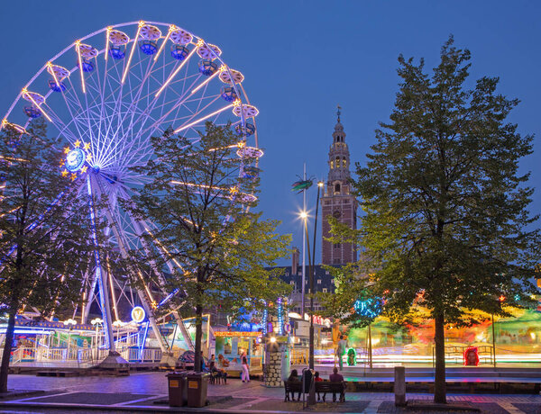 ЛЕУВЕН, БЕЛЬГИЯ - 3 СЕНТЯБРЯ 2013 г.: Парк аттракционов на Монсеньоре Ладеузеплейн - площадь в вечернем закате.