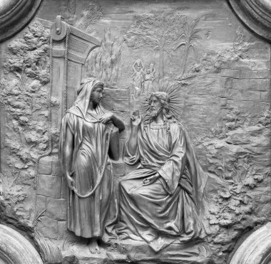 11 Nisan 2018 'de Basilica Collegiata di San Sebastiano' nun kapısındaki kuyuda İsa 'nın Samaritan' lı kadınla bronz bir şekilde rahatlatılması..