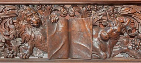 BRUGES, BELGIUM - JUNE 13, 2014: Carved relief of lion and bull as evangelist st. Mark and st. Luke in Karmelietenkerk (Carmelites church) by carmelite Victor van de Heilige Jacob from 17. cent. — Stock Photo, Image