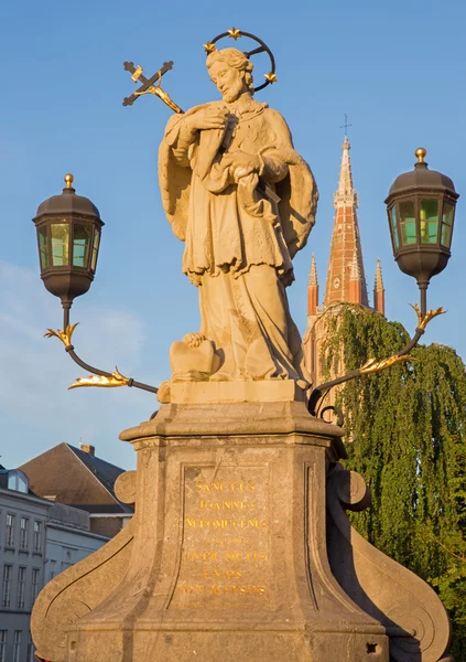 Bruggy - svatého Jana Nepomuckého socha na mostě a na věž kostela Panny Marie. — Stock fotografie