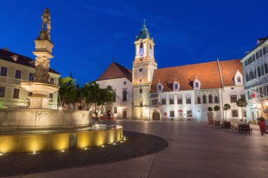 Bratislava, Slovakya - 21 Eylül 2014: akşam karanlığında Belediye Binası ve Cizvitler Kilisesi ile ana meydanında.