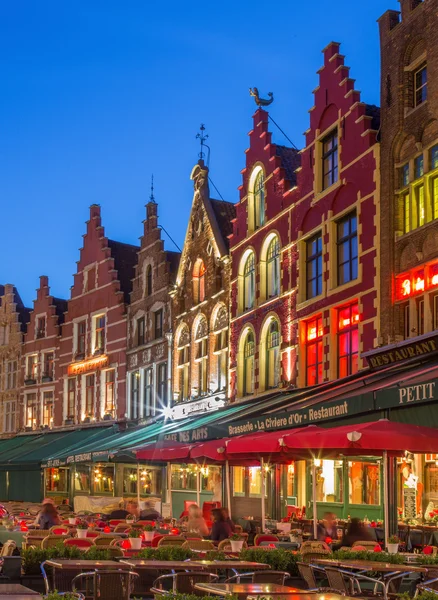 Brugge, België - 11 juni 2014: de huizen van de grote markt vierkant in de schemering. — Stockfoto