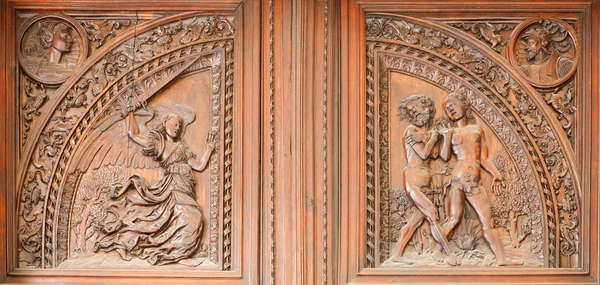 MADRID - MARCH 10: Wooden relief expulsion of Adam and Eva from Paradise scene from indoor gate of Capilla del Obispo in March 10, 2013 in Spain. — Stock Photo, Image