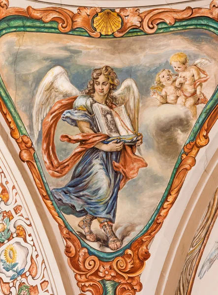 SEVILLE, SPAIN - OCTOBER 28, 2014: The barokk fresko of angel with the liturgy book in church Hospital de los Venerables Sacerdotes av Juan de Valdes Leal (1622-1690) ). – stockfoto