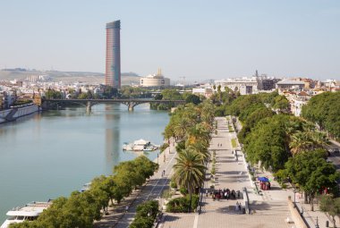 Sevilla, İspanya - 29 Ekim 2014: Torre del Oro Guadalquivir Nehri Rıhtımlar üzerinde mesire ve modern Torre Cajasol--dan görünüm.
