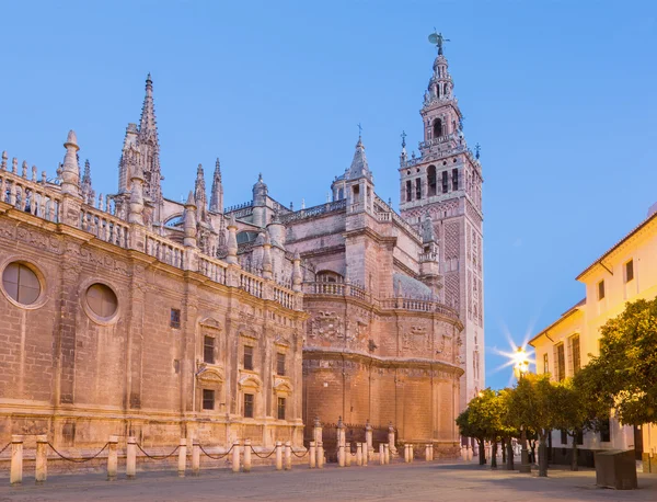 Sevilla - Kathedraal van Santa Maria de la Sede met de klokkentoren van Giralda in de ochtendschemering. — Stockfoto