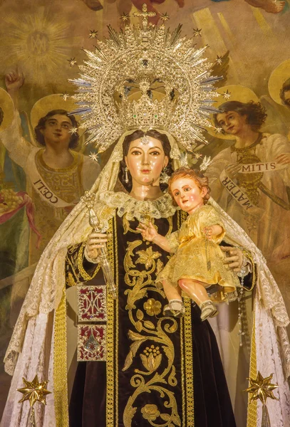SEVILLE, SPANIEN - OCTOBER 30, 2014: Statuen af den traditionelle optjente Madonna (Virgen of Carmen) af Rafael Barbero (1945) på det vigtigste alter barok kirke Iglesia de Buen Suceso . - Stock-foto