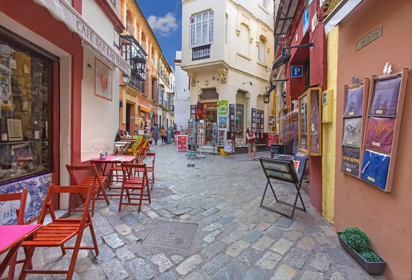 SEVILLE, SPAIN - OCTOBER 28, 2014: Little streets with the shops and restaurants in the Santa Cruz district - Calle Ximenez de Enciso street. — Stock Photo, Image