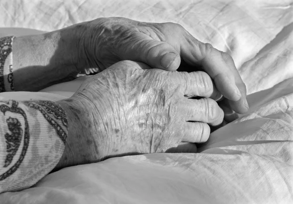 Hands of old woman on the bed — Stock Photo, Image