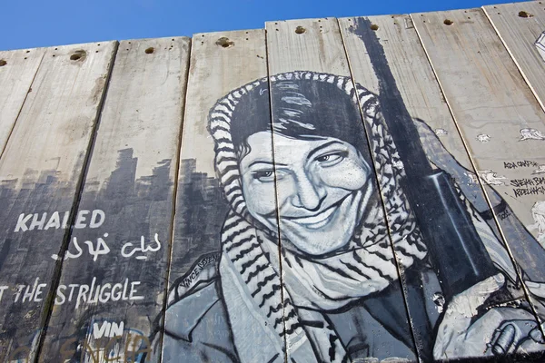 BETHLEHEM, ISRAEL - 6 de marzo de 2015: El detalle del graffitti en la barrera de separación. Mujer palestina con el arma . — Foto de Stock