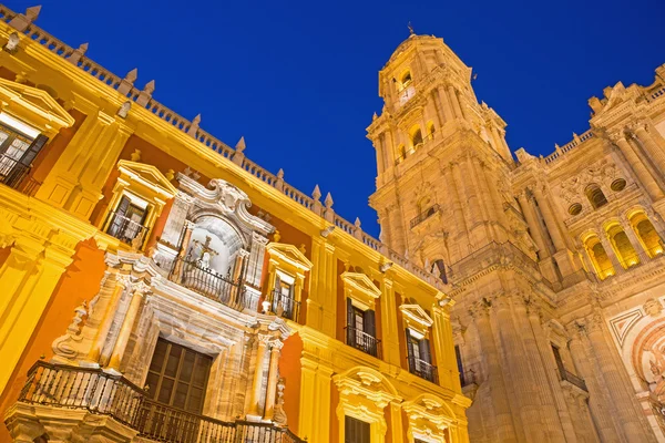 Malaga - domkyrkans torn och barock fasaden på bishops palace i skymningen — Stockfoto