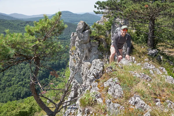 El hombre en la cima de la roca en el trekking — Foto de Stock