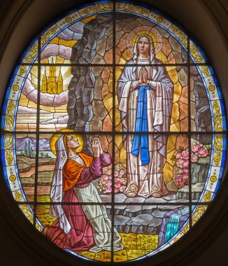 ROME, ITALY - MARCH 26, 2015: The windowpane of Virgin Mary of Lourdens in church Chiesa di Santa Maria Annunziata from year 1958 by artist S. C. J.