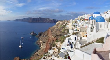 Santorini - Arkadaki kaldera ve Therasia adası üzerinde tipik mavi kilise topları.