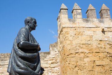 CORDOBA, SPAIN - MAY 25, 2015: The statue of philosopher Lucius Annaeus Seneca the Younger by Amadeo Ruiz Olmos (1913 - 1993) and medieval gate Puerta del Almodovar.