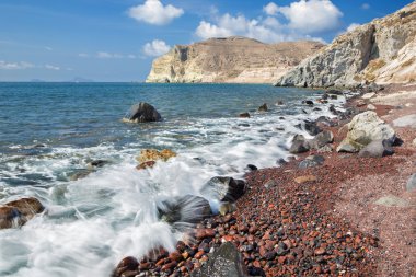 Santorini - adanın güney kısmından kırmızı sahilde dalgalar.