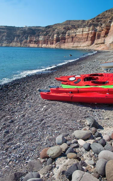 Santorini - Os caiaques na praia negra na parte sul da ilha . — Fotografia de Stock