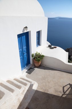 Santorini - The look to typically house ower the caldera with the white stairs and blue dors in Oia.
