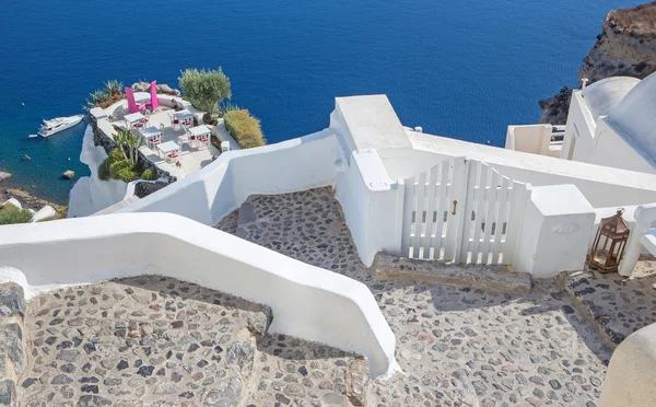 Santorini - Restaurangen är inriktad på bröllop romantisk restaurang i Oia (Ia) och båten under klippor i bakgrunden. — Stockfoto