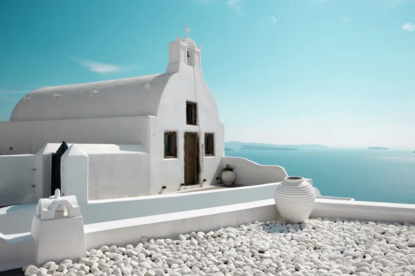 Santorini, Oia 'nın batısındaki küçük beyaz kiliseye bakıyor.. — Stok fotoğraf
