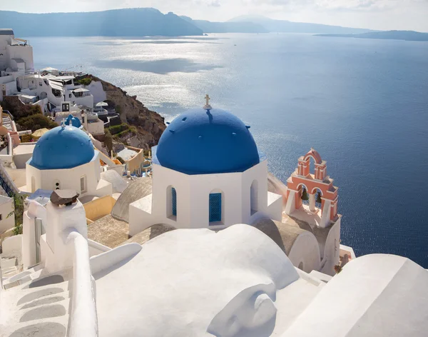 Santorini - utseende till vanligtvis blå kyrkan kupoler i Oia över calderan. — Stockfoto