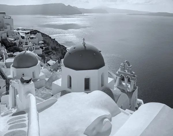 Santorini - utseende till vanligtvis blå kyrkan kupoler i Oia över calderan. — Stockfoto