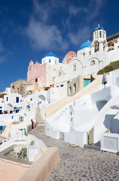 Santorini - La mirada a las cúpulas iglesias típicamente azules en Oia con las escaleras de la casa blanca . —  Fotos de Stock