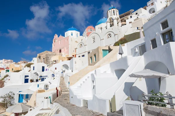 Santorini - La mirada a las cúpulas iglesias típicamente azules en Oia con las escaleras de la casa blanca . —  Fotos de Stock