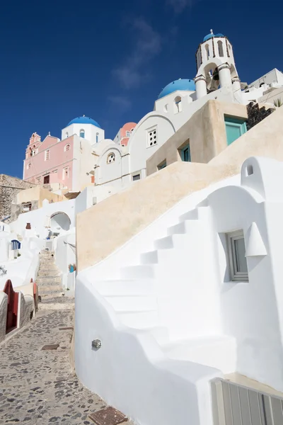 Santorini - La mirada a las cúpulas iglesias típicamente azules en Oia con las escaleras de la casa blanca . —  Fotos de Stock